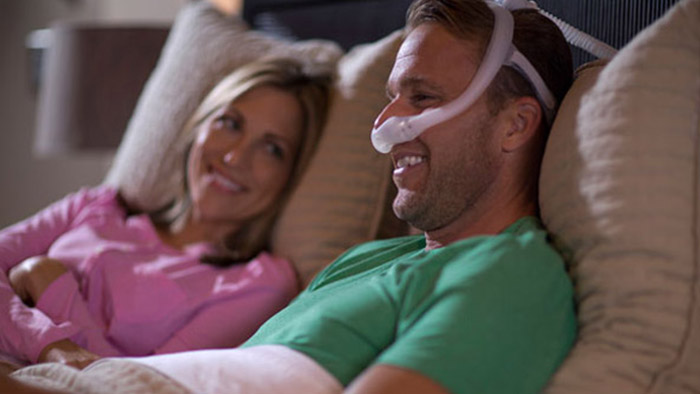 un hombre y una mujer tumbados en un sofá